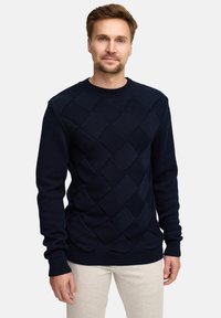 Granatowy sweter z dzianiny z teksturowanym wzorem w diamenty, prążkowanym kołnierzem i mankietami, klasycznym okrągłym dekoltem oraz długimi rękawami.