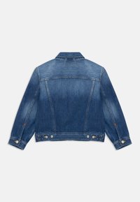 Chaqueta de mezclilla en azul medio con un corte clásico. Presenta un cuello puntiagudo, mangas largas, bolsillos laterales y botones de presión de metal. Tejido texturizado.
