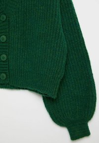 Zielony kardigan dziany z prążkowaną fakturą, z pięcioma okrągłymi guzikami, krótkim krojem i balonowymi rękawami.