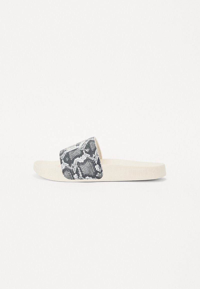 Sorte og hvite slangeskinnmønster sandal med en myk, beige gummi såle. Har en bred stropp og merket logo på siden.