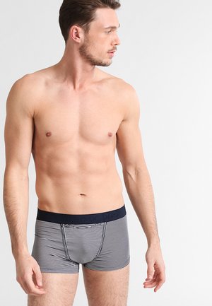 Boxer-briefs rayés en bleu marine et blanc, avec une taille solide bleu marine portant un logo. Design ajusté fabriqué dans un matériau doux.