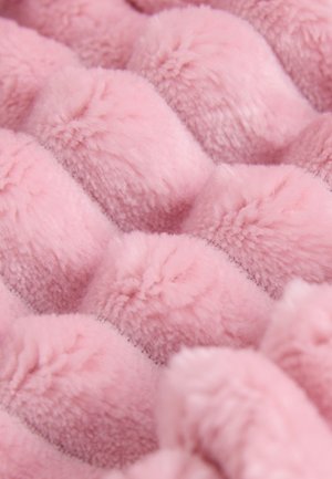 Lyserødt plysstof med en tekstureret, bølget overflade med bløde, hævede knopper. Materialet fremstår fluffy og indbydende.