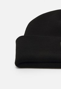 Μαύρο πλεκτό καπέλο με πτυχωτό μανίκι, χαρακτηρισμένο από ραβδωτή υφή χωρίς ορατά λογότυπα ή διακοσμήσεις. Απλός και μονοχρωματικός σχεδιασμός.