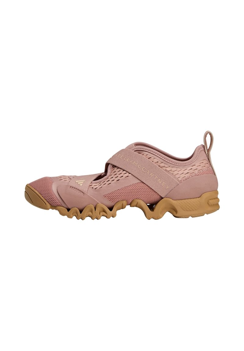 Light pink athletic shoe with a textured mesh upper, elastic strap, and a flexible rubber sole featuring a wavy design.