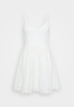 Vestido branco, sem mangas, com um corpete texturizado e estampado e saia ampla. Apresenta alças finas e acabamento em renda na barra.