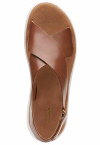 Sandalo in pelle marrone con design a fascia incrociata. Soletta interna marrone morbida e suola in gomma bianca. Dettaglio del logo ben visibile sulla soletta. Profilo piatto.