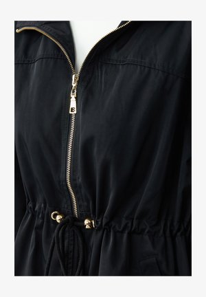 Zwarte zip-up jas met een gouden rits, cinched taille, verstelbare trekkoord en een gladde textuur. Bevat een capuchon en elastische manchetten.
