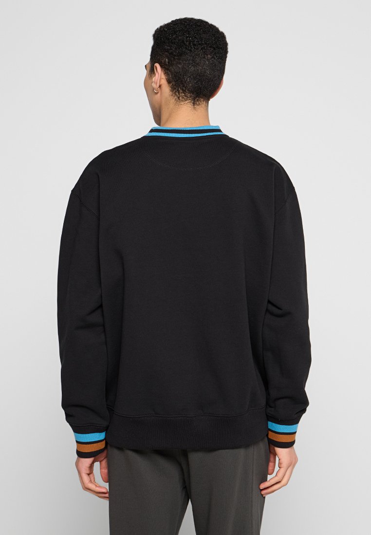 Czarny sweatshirt o luźnym kroju, z prążkowanymi mankietami i kołnierzem, zdobiony niebieskimi i brązowymi paskami. Gładka tekstura z minimalnymi detalami.