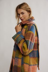 Casaco de lã às quadrículas com cores vibrantes: azul, amarelo, laranja e rosa. Gola espessa, punhos com botões e tecido texturizado.