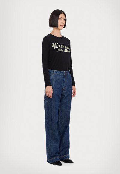 Langermet svart T-skjorte med "Weekend Max Mara" trykket i krem, kombinert med vide blå denimjeans. Glatt stoff og avslappet passform.