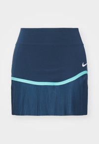 Falda pantalón Nike en azul marino oscuro con parte superior ajustada y sección inferior plisada. Presenta un ribete azul claro contrastante y el icónico logo en el lateral.