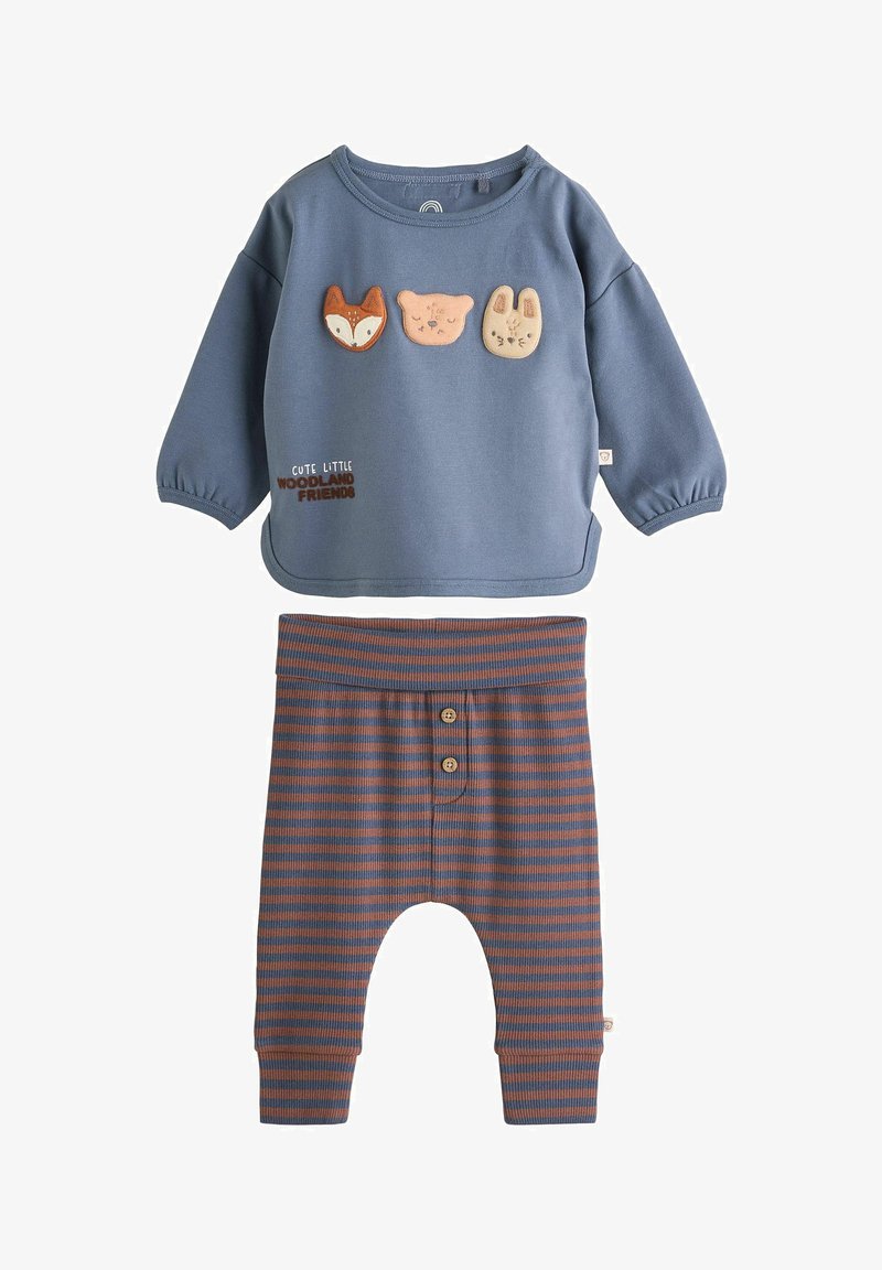 T-shirt bleu à manches longues pour tout-petit avec des visages de renard, d’ours et de lapin, et un pantalon rayé marron et bleu avec des boutons à l’avant.
