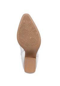 Suela de zapato de cuero blanco con una banda de goma texturizada que presenta patrones geométricos. Tacón resistente en color natural.