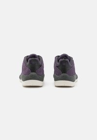 Lila velúr gördeszkás cipők fekete részletekkel, kerek formával, párnázott bokával és texturált gumitalppal; a Nike márkajelzése látható rajtuk.