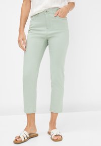 Hellgrüne, hochtaillierte Jeans mit schmaler Passform und verkürzter Länge. Strukturierter Baumwollstoff mit klassischem Fünf-Taschen-Design.