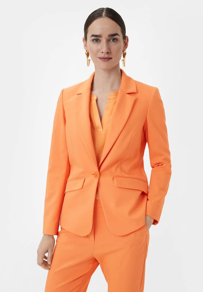 Oranger Anzugjacke mit taillierter Passform, einreihiger Knopfverschluss, Reverskragen und zwei Fronttaschen, kombiniert mit einem passenden Oberteil.