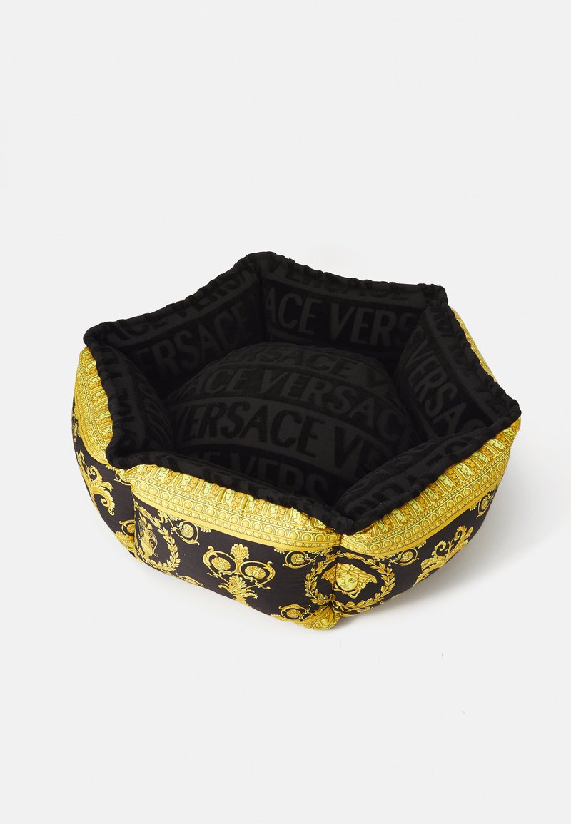 Juodas ir auksinis gyvūnų lova šešiakampio forma, su minkštu aksominiu paviršiumi ir ryškiu Versace logotipo raštu bei dekoro motyvais.