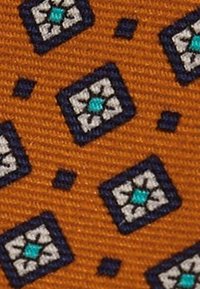 Narancssárga alapon szövet sötétkék és fehér négyzetmintával, mindegyik közepén türkizszínű gyémánt alakzat található.