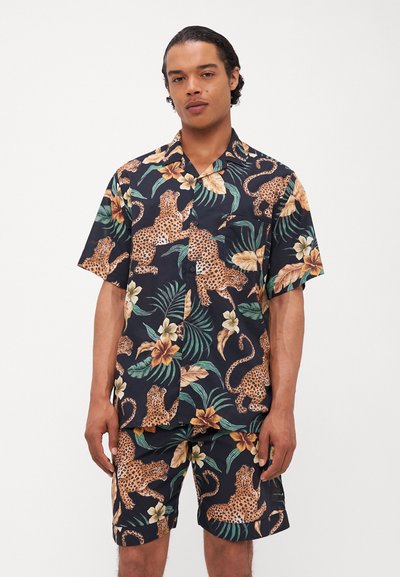 Kurzärmliges navi-blaues Hemd und passende Shorts aus leichtem Stoff, mit floralem und Leopardenmuster in warmen Farben.