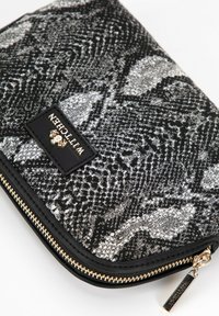 Clutch nero e argento con motivo, realizzato in tessuto testurizzato, dotato di zip in metallo dorato e di una patch con logo in pelle nera sulla parte anteriore.