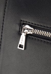 Czarny skórzany suwak z srebrnymi elementami metalowymi, z teksturowaną powierzchnią i widoczną zawieszką z ikoną wykrzyknika.