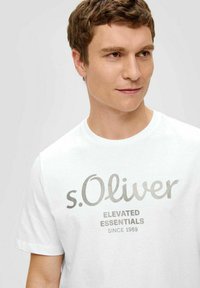 White short-sleeve t-shirt featuring a prominent grey logo and text design. Fabric appears soft with a classic crew neckline.
