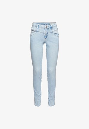 Jeans ajustados de color azul claro con botón frontal, bolsillos con cremallera y pasadores para cinturón, exhibidos sobre un fondo blanco.