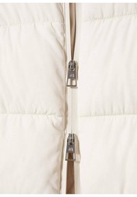 Krémová prošívaná bunda s předním zipem, s hladkou texturou a prošitými částmi. Kovové zipové kování s logem.