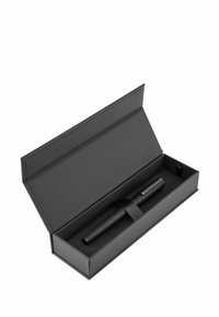 Zwarte pen in een matte zwarte rechthoekige doos, vastgemaakt met een zwart elastiek. De doos heeft een gladde, vlakke oppervlakte zonder zichtbare patronen.