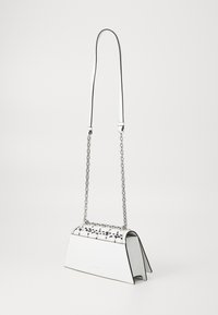 White handbag with a wedge shape, featuring a textured black-and-white patterned top, silver chain strap, and contrasting black trim.