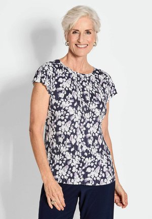 Marinebluse mit Blumenmuster und kurzen Ärmeln, mit weißen und helllila Blumenmustern, plissierter Textur, runder Halslinie und weichem Stoff.