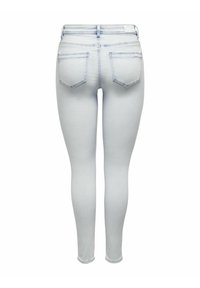 Uske traperice u svijetloplavom denimu s bešavnim strukom, dva stražnja džepa i prilagodljivim dizajnom nogavica. Glatka tekstura s minimalnim šavovima.