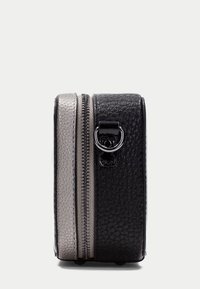 Borsa strutturata bicolore nera e argento con finitura testurizzata, dotata di chiusura con zip e dettaglio in metallo a forma di anello sul lato.