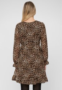 Leopardenmusterkleid mit langen Ärmeln, taillierter Taille und rüschengesäumtem Saum. Hergestellt aus leichtem Stoff mit glatter Textur.