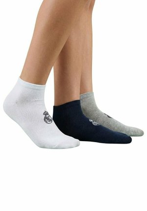 Trzy nogi w skarpetkach za kostkę w kolorach białym, granatowym i szarym, każda z małym czarnym logo w pobliżu kostki.