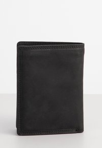 Portafoglio bifold in pelle nera in posizione verticale su una superficie bianca, con cuciture visibili lungo i bordi.