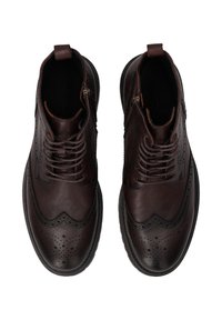 Brązowe skórzane botki za kostkę z wzorem w skrzydła, złożonymi perforacjami i zapięciem na zamek. Teksturowana powłoka i kontrastowa czarna podeszwa.