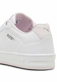 Λευκό αθλητικό παπούτσι Puma με ανοιχτό ροζ εσωτερική επένδυση και ταμπελάκι στη φτέρνα, με το λογότυπο Puma στο πλάι, τη φτέρνα και την σόλα.