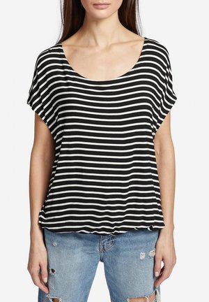 Camiseta de rayas blancas y negras con escote en forma de barco y mangas cortas, hecha de una tela suave, combinada con jeans ligeros de mezclilla desgastados.