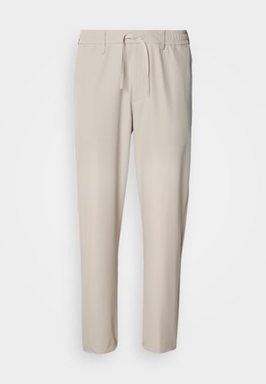 Pantalones beige y ligeros con un corte holgado. Cuentan con una cintura elástica con cordón y bolsillos laterales. Textura suave y sin estampados.