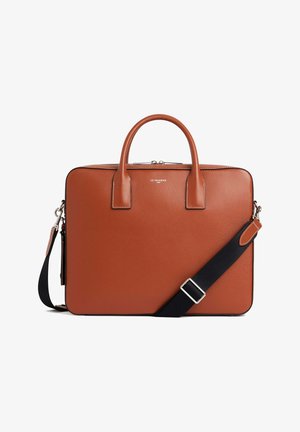 Leather briefcase in burnt orange with top handles, a removable black shoulder strap, and subtle stitch detailing along the edges.