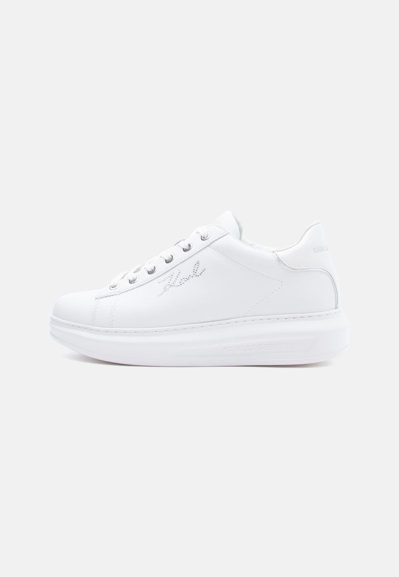 White leather sneakers with a rubber sole, round toe, flat laces, and subtle logo detailing on the side and back. Smooth texture.