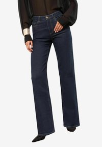 Blugi evazați de culoare albastru închis, confecționați din denim; au buzunare frontale, închidere cu nasture și un design clasic cu cinci buzunare. Textură moale.