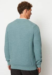 Hellblauer, gerippter Pullover mit Rundhalsausschnitt, langen Ärmeln und strukturierter Oberfläche. Besitzt eine lockere Passform sowie gerippte Bündchen und Saum.