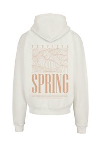 Hættebluse i off-white med et stort grafisk design med lyse ferskenfarvede tekst og bladmønstre på ryggen.