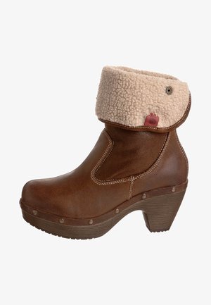 Brown leather ankle boot with a faux shearling cuff, rounded toe, stacked heel, decorative stitching, and metal studs on the sole.
