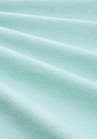 Lyseblåt stof med en glat tekstur, der har bløde, flydende folder og en ensartet overflade. Ingen tydelige mønstre eller hardware synlige.