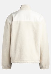 Weiße Kunstpelzjacke mit hohem Kragen, ausgestattet mit einem oberen Teil aus glattem Stoff und einem strukturierten Körper. Elastische Bündchen und eine lockere Passform.
