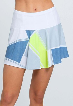 Blick von der Taille abwärts auf eine Person, die einen weißen Tennisrock mit blauen, grauen und gelben geometrischen Mustern trägt.