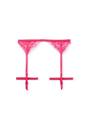 String en dentelle rose avec des sangles en satin, présentant un bord festonné et des rubans latéraux ajustables. Le design ouvert à l'arrière souligne une couverture minimale.